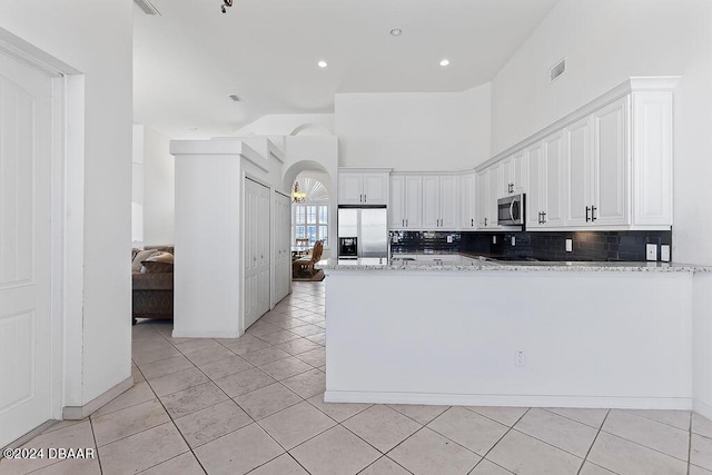 kitchen with white cabinets, stainless steel appliances, and light tile patterned floors