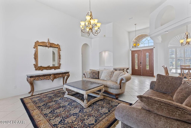 living room with light tile patterned flooring, a high ceiling, and an inviting chandelier