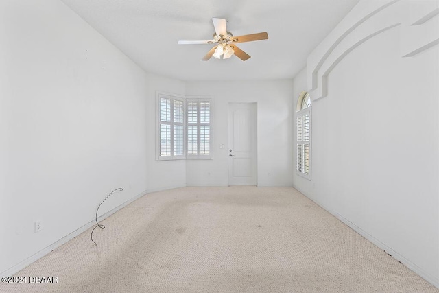 unfurnished room featuring ceiling fan, a healthy amount of sunlight, and light carpet