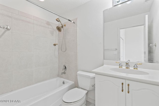 full bathroom featuring vanity, toilet, a textured ceiling, and tiled shower / bath combo