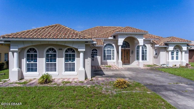 mediterranean / spanish home featuring a front lawn