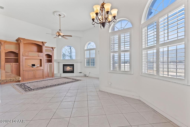 unfurnished living room with light tile patterned floors and ceiling fan with notable chandelier