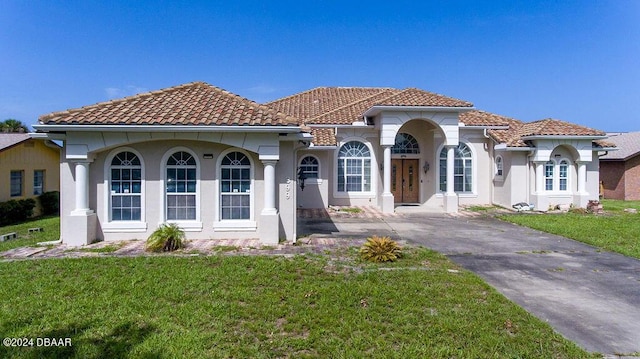 mediterranean / spanish-style home featuring a front yard