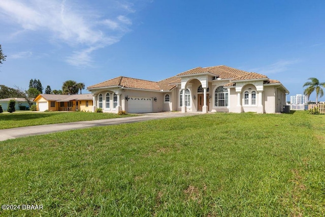 mediterranean / spanish home featuring a front lawn and a garage