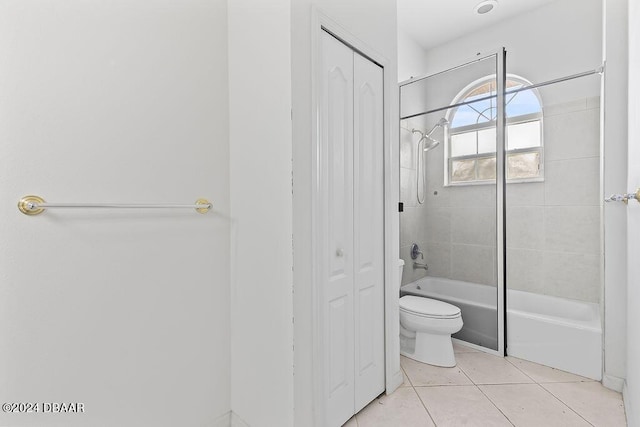 bathroom with toilet, tiled shower / bath combo, and tile patterned floors