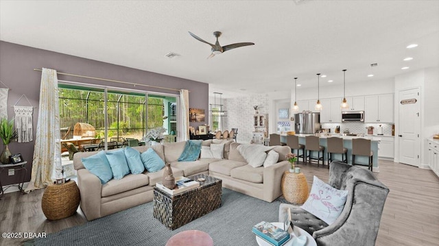 living room featuring ceiling fan and light wood-type flooring