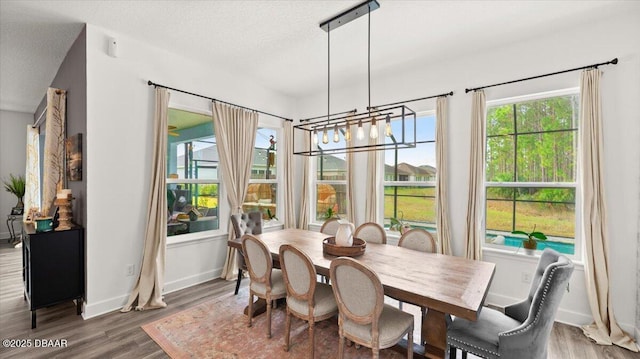 dining room with an inviting chandelier, wood-type flooring, and a textured ceiling