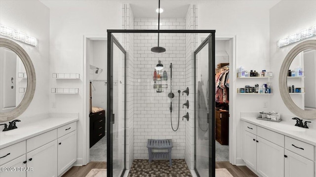 bathroom with hardwood / wood-style flooring, vanity, and a shower with shower door