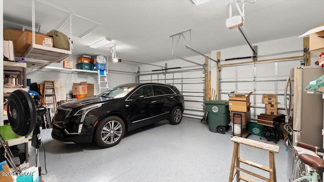 garage with a garage door opener and stainless steel fridge