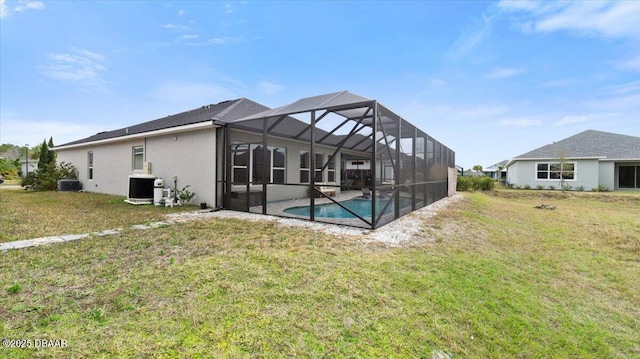 back of property with central AC unit, glass enclosure, and a lawn