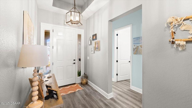 entrance foyer with an inviting chandelier and hardwood / wood-style floors