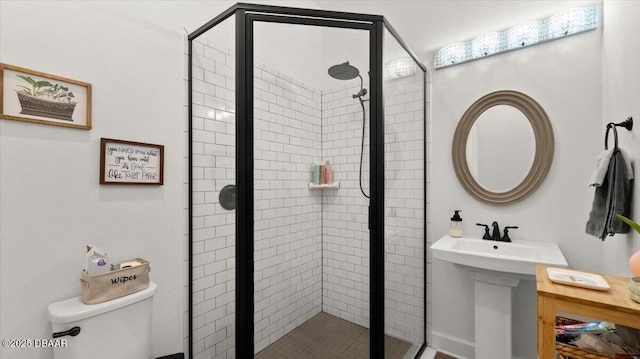 bathroom featuring toilet, an enclosed shower, and sink