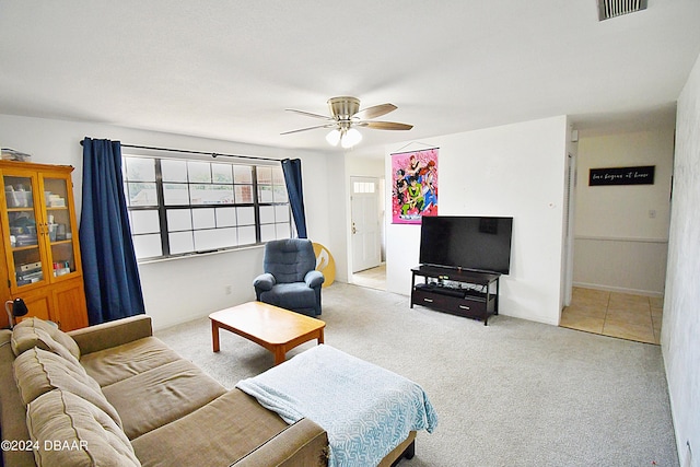 living area featuring a ceiling fan, visible vents, and light carpet