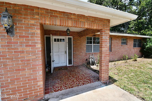 view of exterior entry featuring brick siding