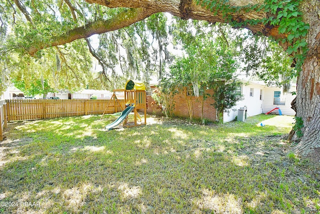 view of yard featuring a playground and a fenced backyard