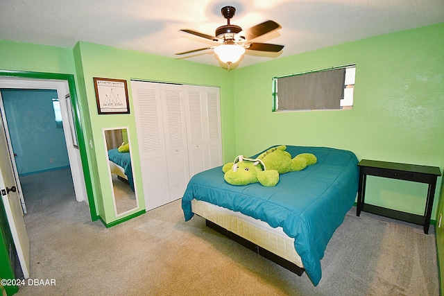 bedroom featuring a closet, light carpet, and ceiling fan