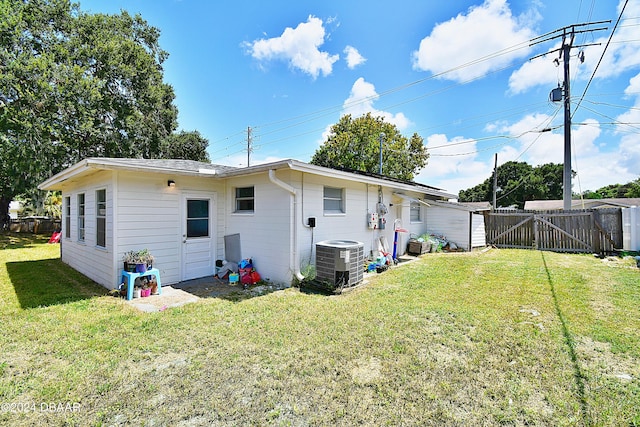 back of house featuring a gate, central AC, a lawn, and fence