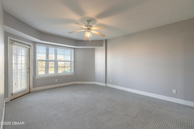 empty room with baseboards, carpet flooring, a textured ceiling, and a ceiling fan