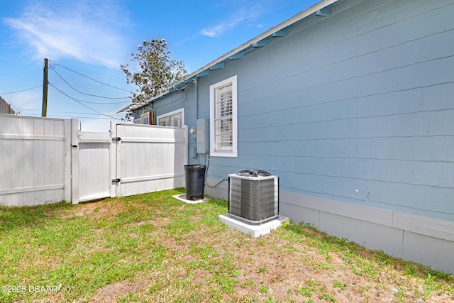 530 Ronnoc Ln, New Smyrna Beach, FL 32168 - view of home's exterior with central AC, a gate, fence, and a lawn