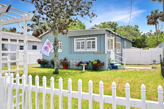 530 Ronnoc Ln, New Smyrna Beach, FL 32168 - bungalow-style house featuring entry steps, a front lawn, and fence private yard