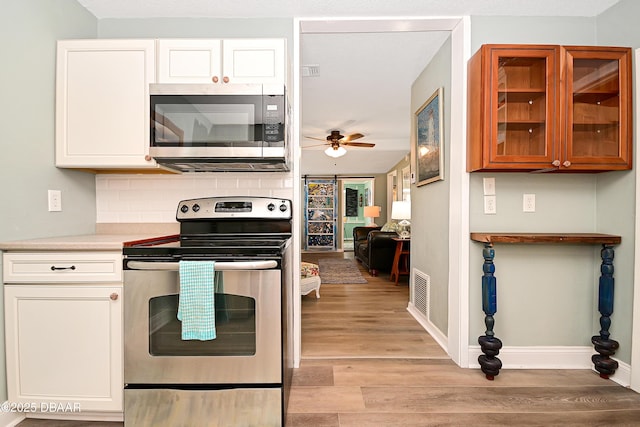 530 Ronnoc Ln, New Smyrna Beach, FL 32168 - kitchen with a ceiling fan, decorative backsplash, appliances with stainless steel finishes, and light wood finished floors