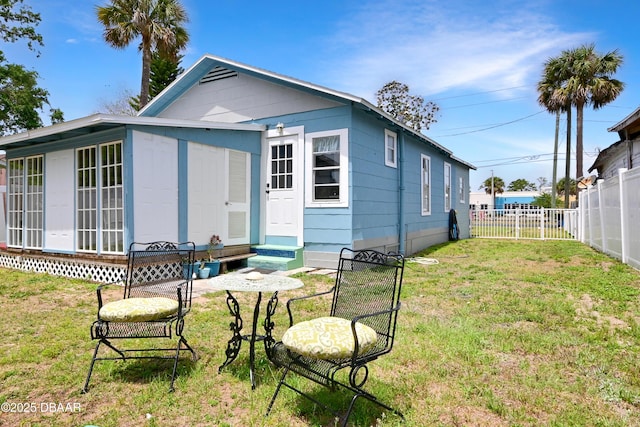 530 Ronnoc Ln, New Smyrna Beach, FL 32168 - back of property with a lawn, a fenced backyard, and entry steps