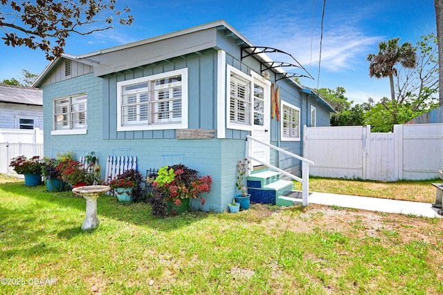 530 Ronnoc Ln, New Smyrna Beach, FL 32168 - view of front facade featuring fence, board and batten siding, entry steps, and a front yard
