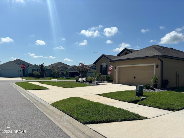 view of front of property featuring a front yard and a garage