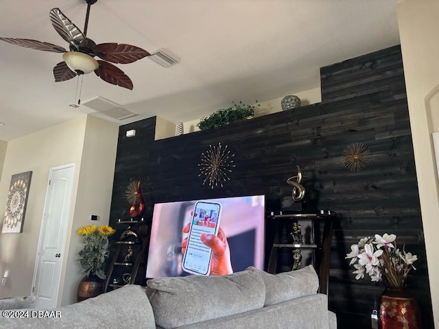 living room with wooden walls and ceiling fan