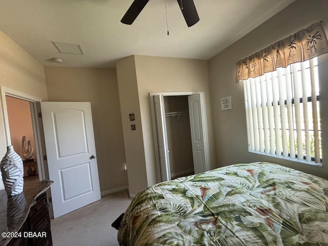 bedroom with a textured ceiling, light carpet, ceiling fan, and a closet