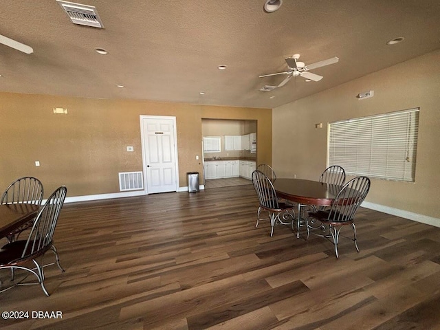 dining space with dark wood-type flooring, ceiling fan, and a textured ceiling