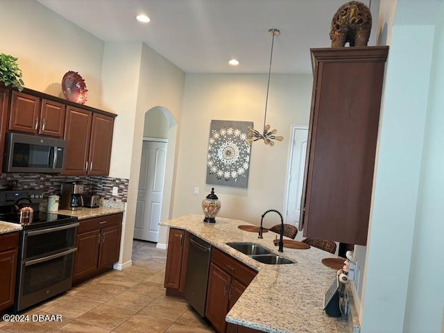 kitchen with stainless steel appliances, sink, tasteful backsplash, light stone countertops, and decorative light fixtures