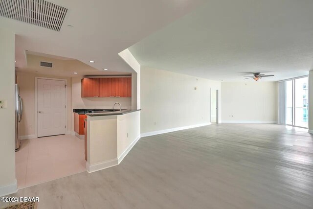 kitchen featuring stainless steel refrigerator, ceiling fan, and light hardwood / wood-style floors