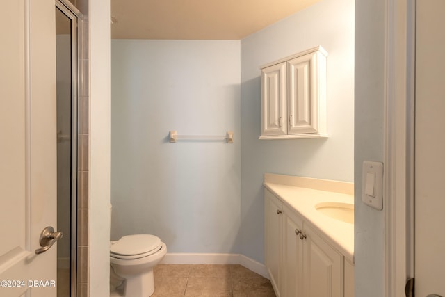 bathroom with toilet, vanity, tile patterned floors, and a shower with door