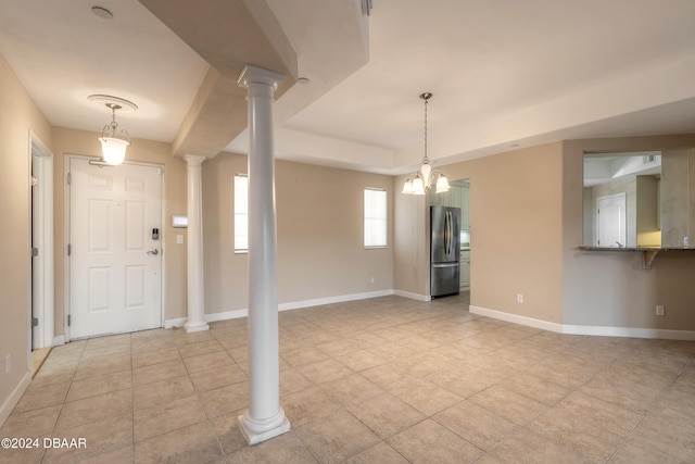 tiled foyer entrance featuring a notable chandelier and decorative columns