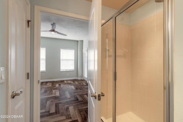 bathroom featuring ceiling fan, parquet floors, and an enclosed shower