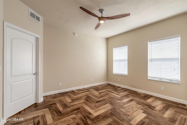 unfurnished room featuring ceiling fan and dark parquet flooring