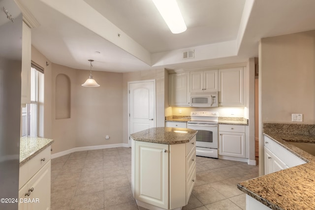 kitchen featuring pendant lighting, a center island, white appliances, and light stone countertops