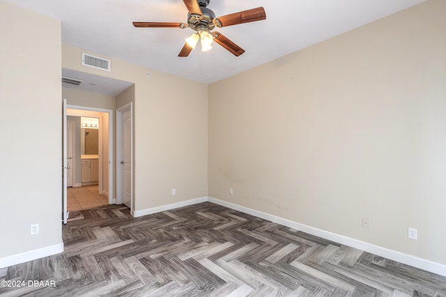 unfurnished room with dark parquet floors and ceiling fan