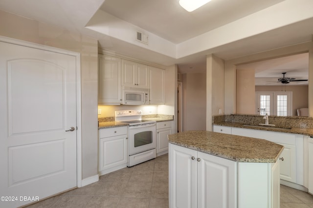 kitchen featuring a kitchen island, white cabinetry, white appliances, and sink