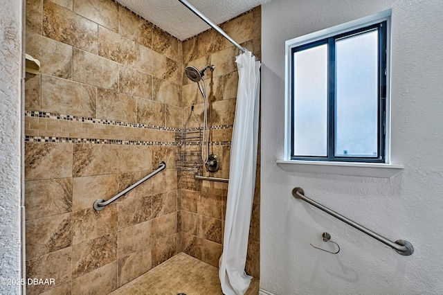 bathroom featuring a textured ceiling and a shower stall