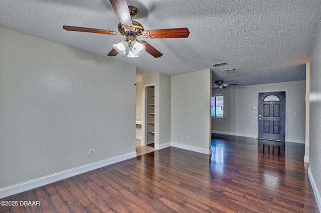 spare room with visible vents, baseboards, ceiling fan, wood finished floors, and a textured ceiling