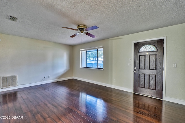 foyer entrance with visible vents and dark wood-type flooring