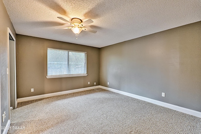 unfurnished room featuring carpet floors, ceiling fan, baseboards, and a textured ceiling