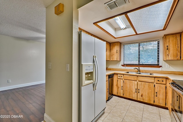 kitchen with stainless steel electric stove, light countertops, visible vents, a sink, and white fridge with ice dispenser