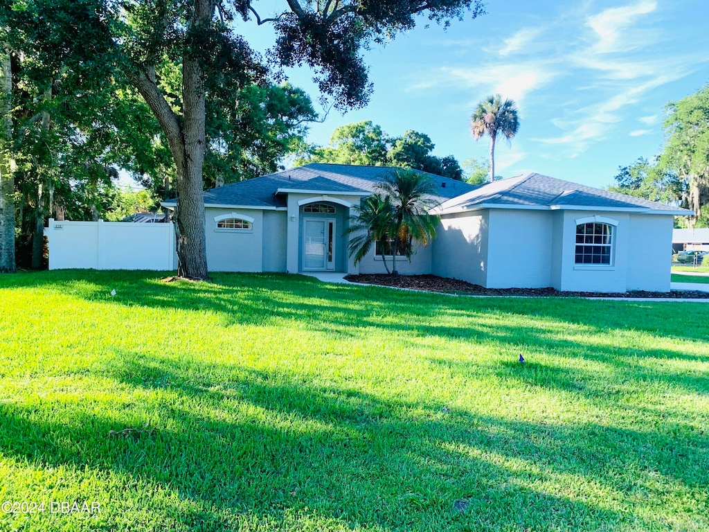 ranch-style home featuring a front yard