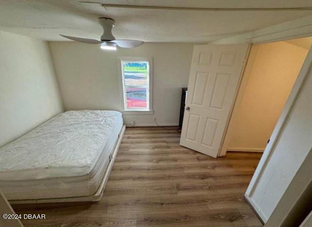 bedroom featuring ceiling fan, wood finished floors, and baseboards