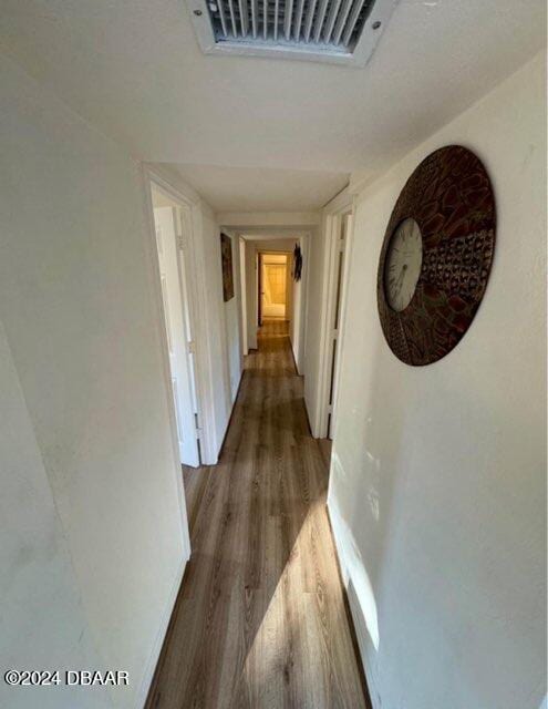 corridor with visible vents and wood finished floors