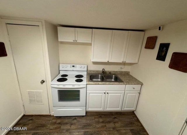 kitchen featuring dark wood-type flooring, a sink, visible vents, white cabinets, and white range with electric cooktop