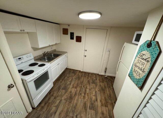 kitchen featuring electric stove, dark wood-type flooring, a sink, and white cabinets